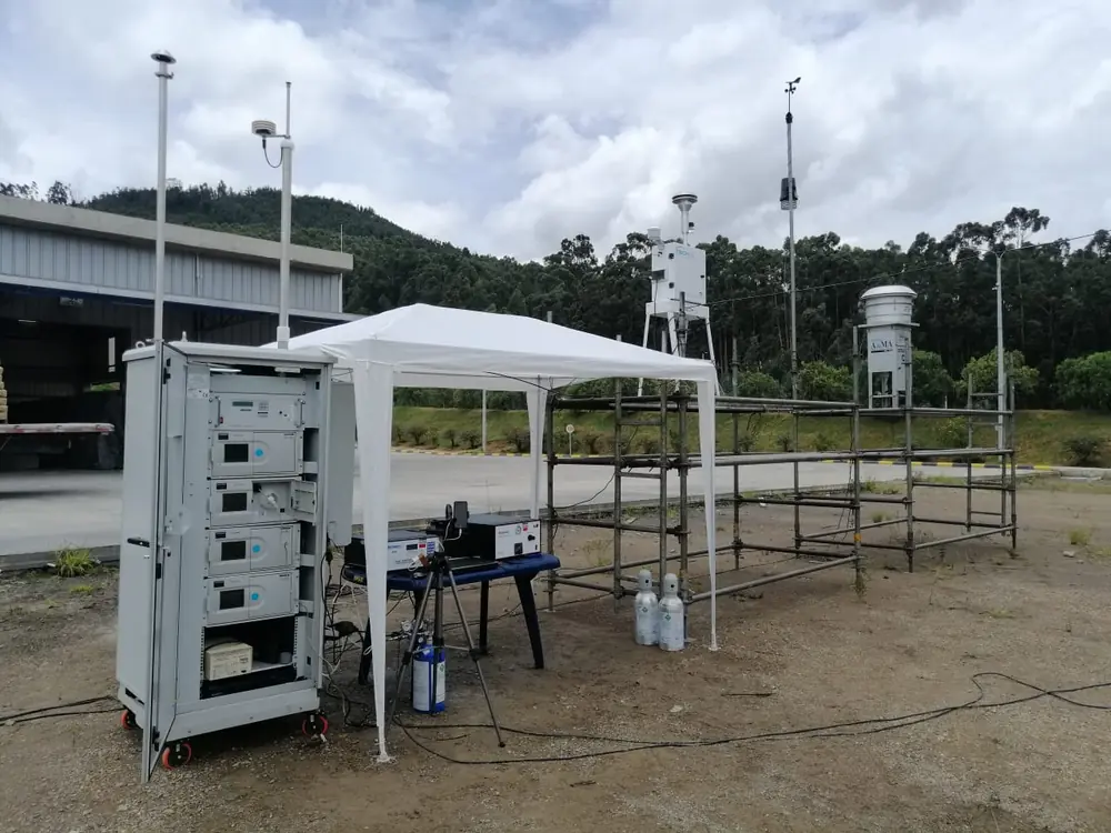 Estación de monitoreo de calidad del aire en campo, con analizadores automáticos, muestreadores de material particulado y torre meteorológica